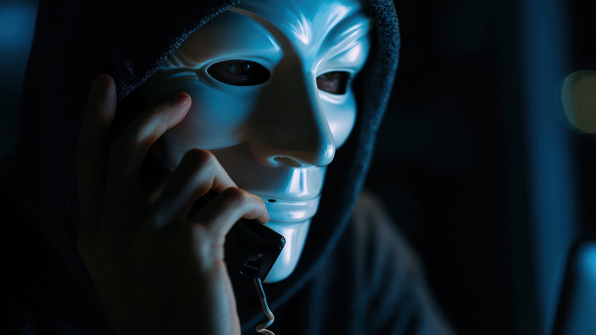 Masked Scammer on phone in call center