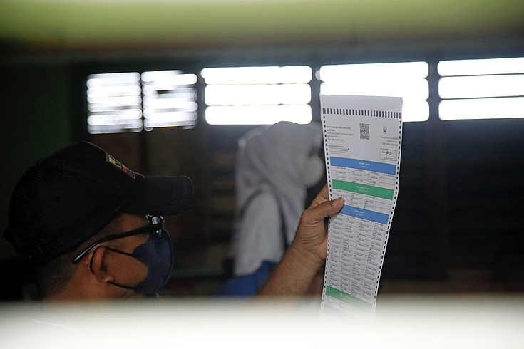A voter inside the classroom in Cotabato City Elementary School inspects the COMELEC issued ballot for the 2022 national and local elections